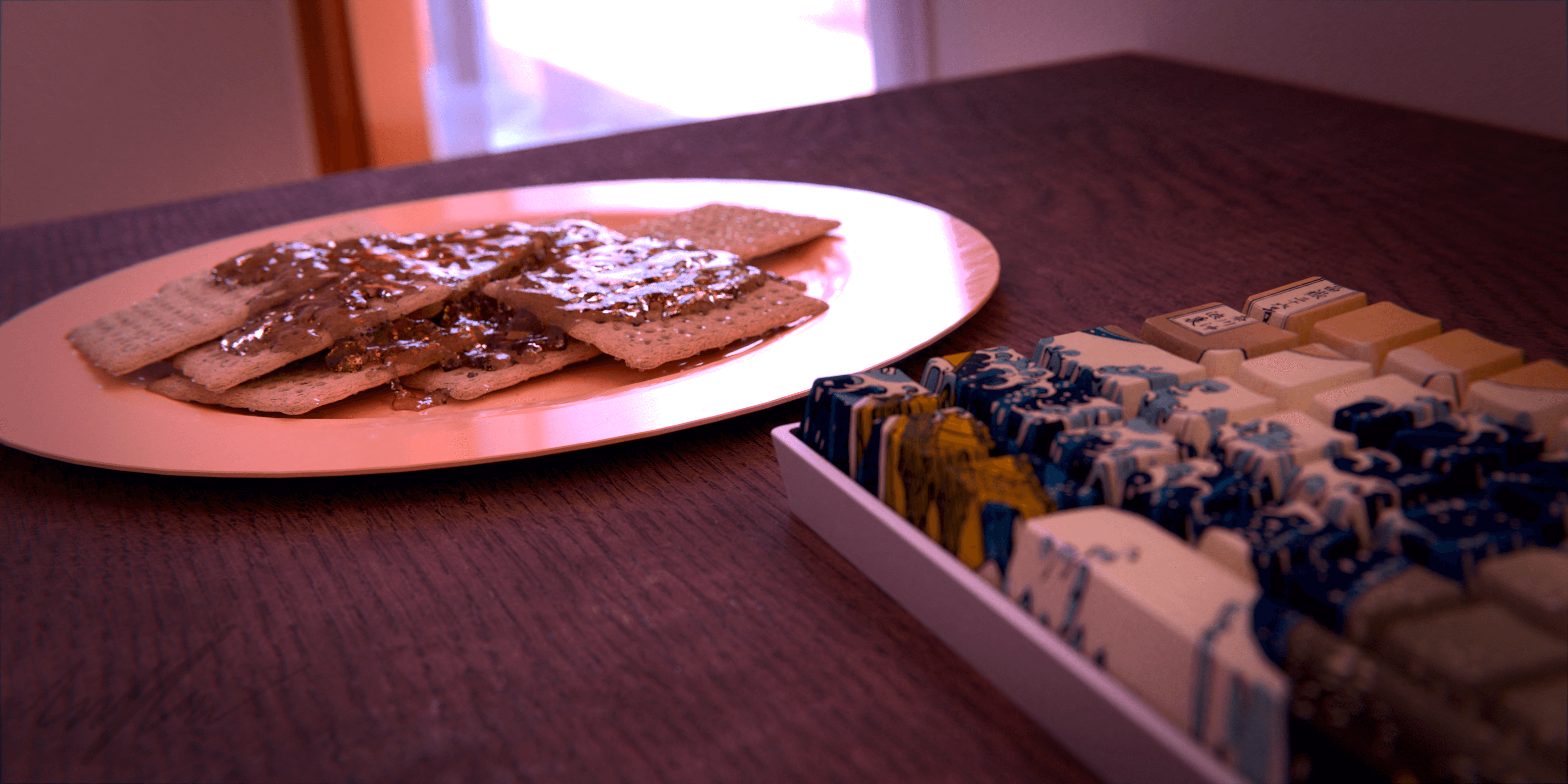 A still shot of a plate of honey on crackers sitting on a desk next to a keyboard, in the morning sun.